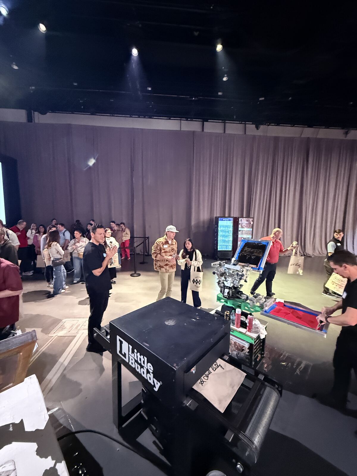 Event attendees at multiple printing stations with equipment and displays
